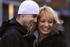 Foto på ett par som leende lutar huvudena förtroligt mot varandra.